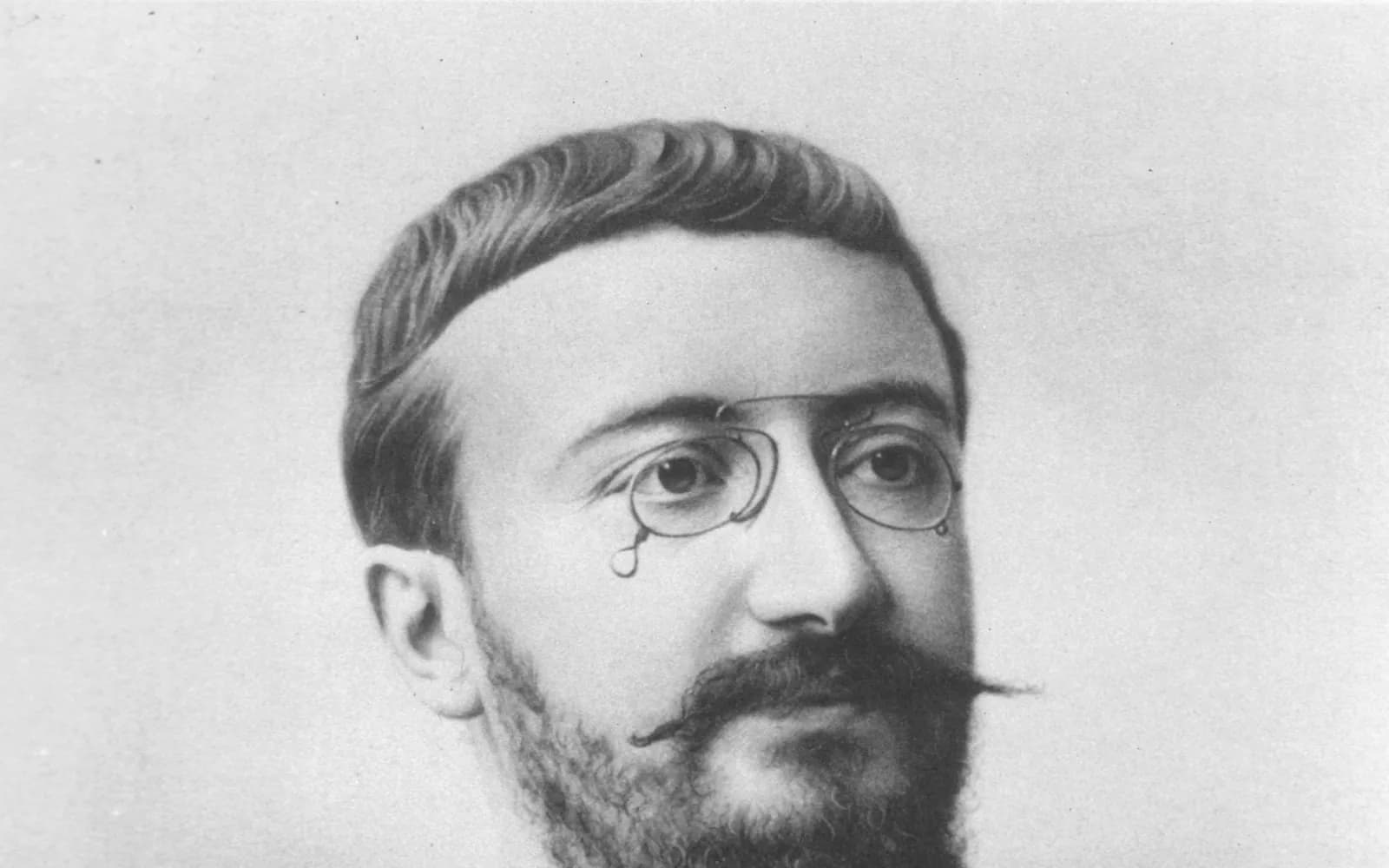 Black-and-white portrait photograph of Alfred Binet, a bearded man with a moustache and pince-nez glasses, looking slightly to the side